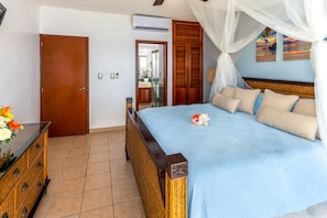 A bedroom with a bed, wooden wardrobe, and a dresser.