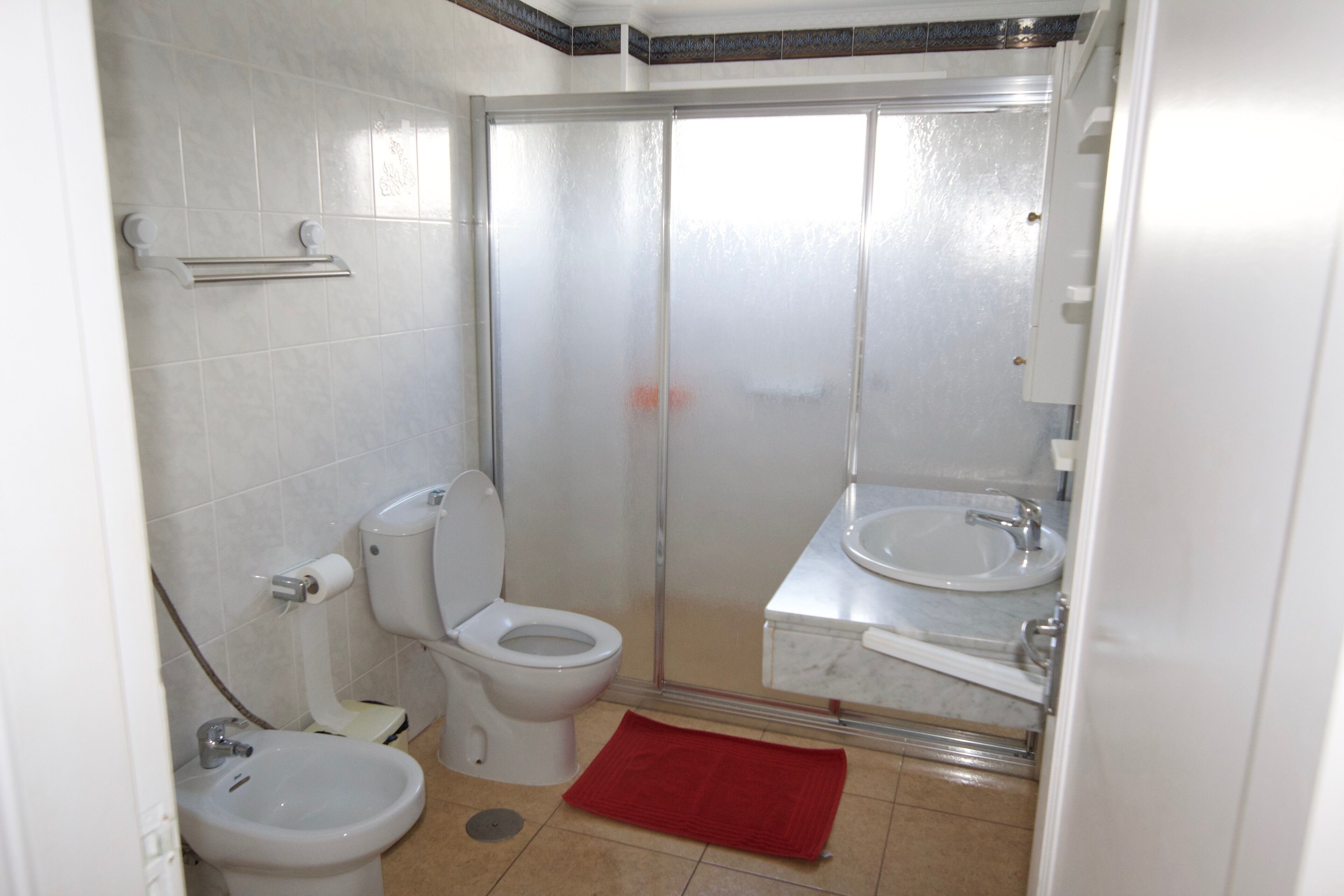 Un bagno con WC, bidet e cabina doccia.