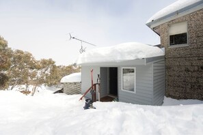 Ett hus med ett snötäckt tak och en garageport.