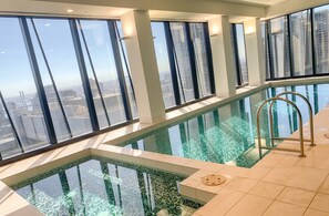 Ein Hochhaus mit einem gläsernen Infinity-Pool und Blick auf die Stadtlandschaft.