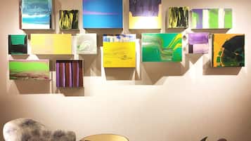 A room with a wall-mounted art display and a patterned armchair.