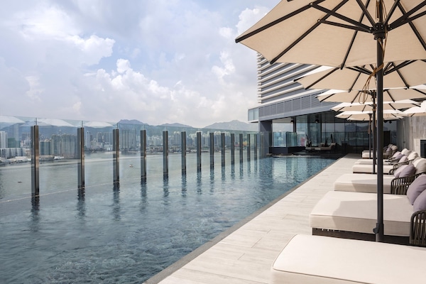 Una piscina al aire libre de temporada, sombrillas