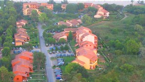 An aerial view of a residential area with multiple buildings, a central road, and parked cars. - Standing Apartment, Facing the Sea! (Ghisonaccia)
