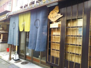 A traditional Japanese building with a sign reading "Green House" and a wooden sign with Japanese characters.