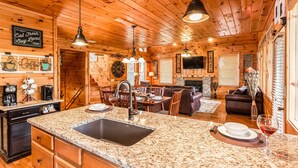 A cozy cabin interior with a kitchen, dining area, and living room.