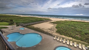 A pool area with two pools, a beach, and a boardwalk. - Beach More, Worry Less: 10% Off on 7+ Night Stays! (South Padre Island)