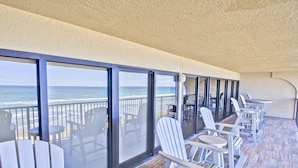 A balcony with a view of the ocean, furnished with white chairs and tables. - Beach More, Worry Less: 10% Off on 7+ Night Stays! (South Padre Island)