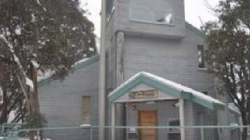 A two-story building with a gabled roof and a front entrance.