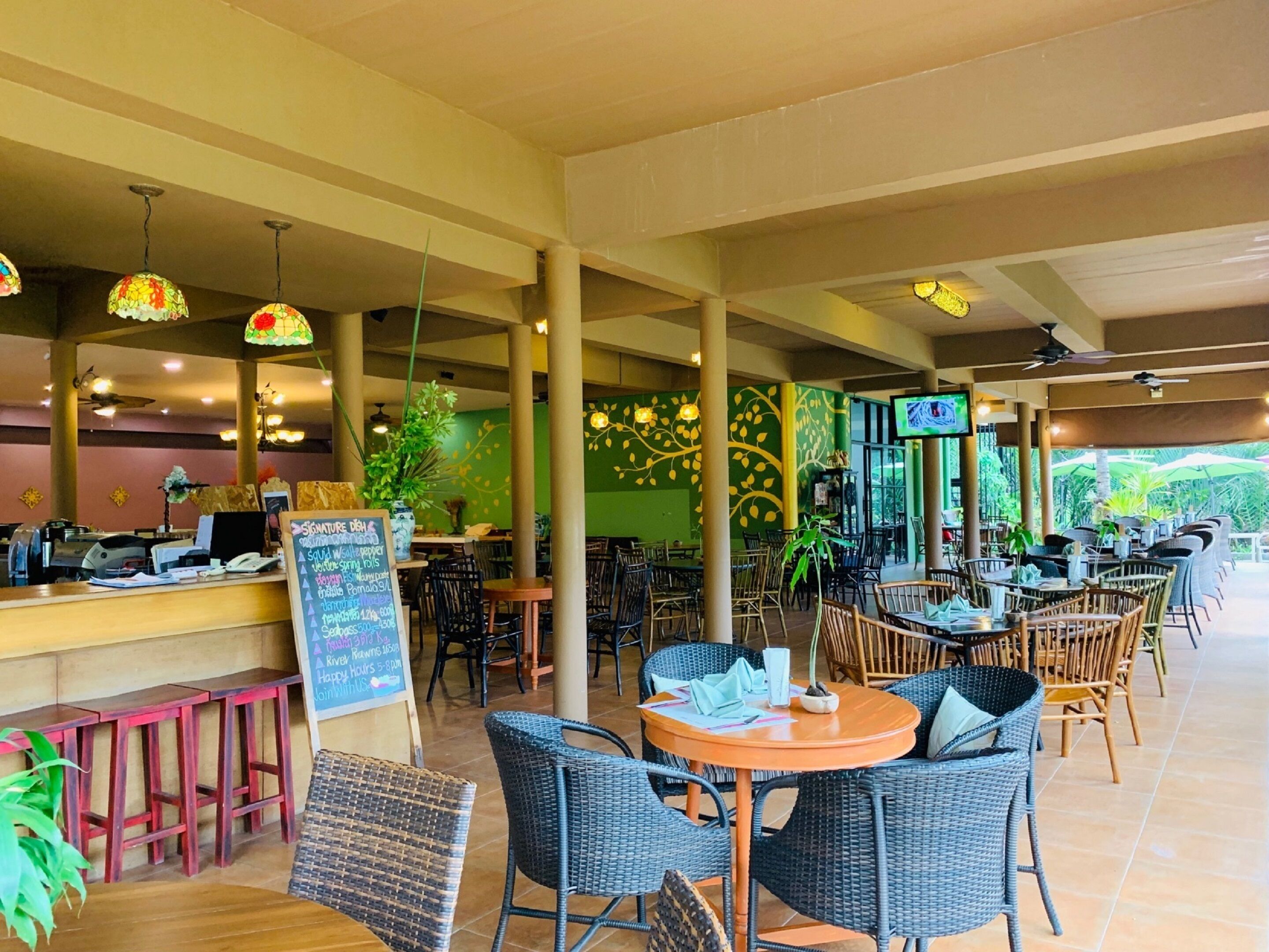 A restaurant with outdoor seating, a counter with a menu, and a chalkboard sign.