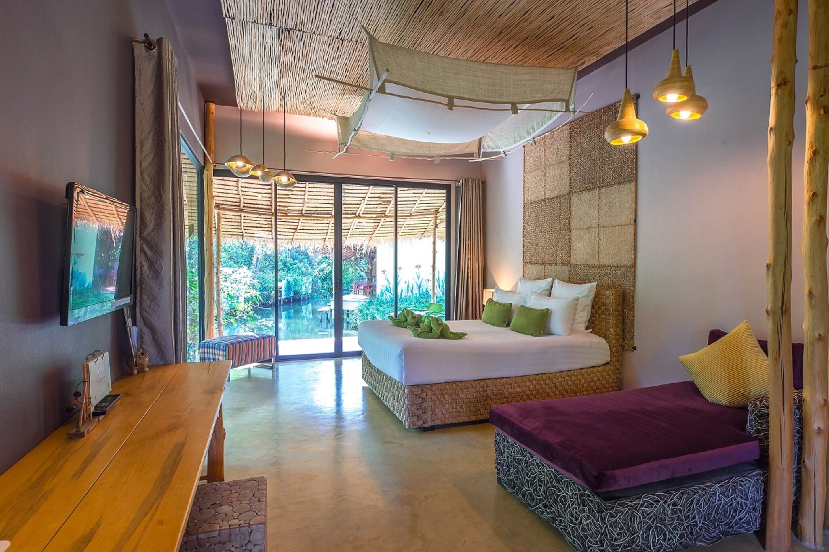 Un dormitorio con cama, escritorio y vistas al exterior.