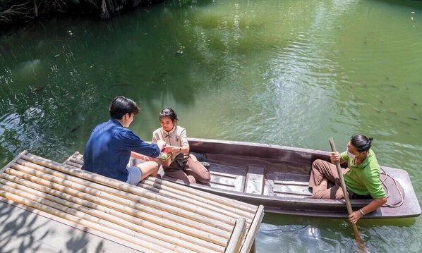 A group of people in a small boat on a calm river. - Asita Eco Resort (Samut Songkhram)