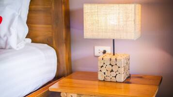 A wooden bedside table with a lamp and a stack of logs.