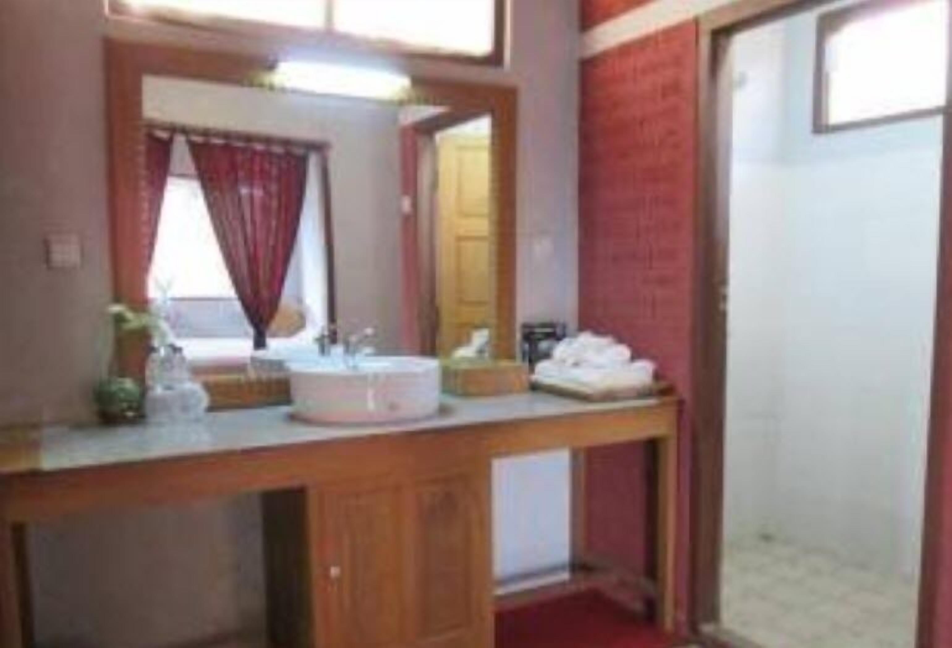A bathroom with a wooden vanity, a sink, and a mirror.