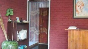 A room with a wooden door, a green vase, and a framed picture on the wall. - Pyi1 Guest House (Nyaungshwe)