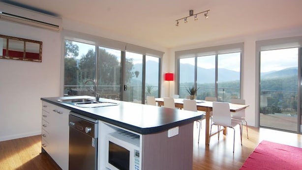 A modern kitchen with a built-in microwave, a dishwasher, and a large island with a sink.