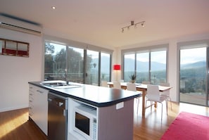 A modern kitchen with a built-in microwave, a dishwasher, and a large island with a sink.
