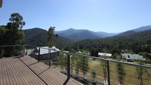 A wooden deck with a view of a mountainous landscape.
