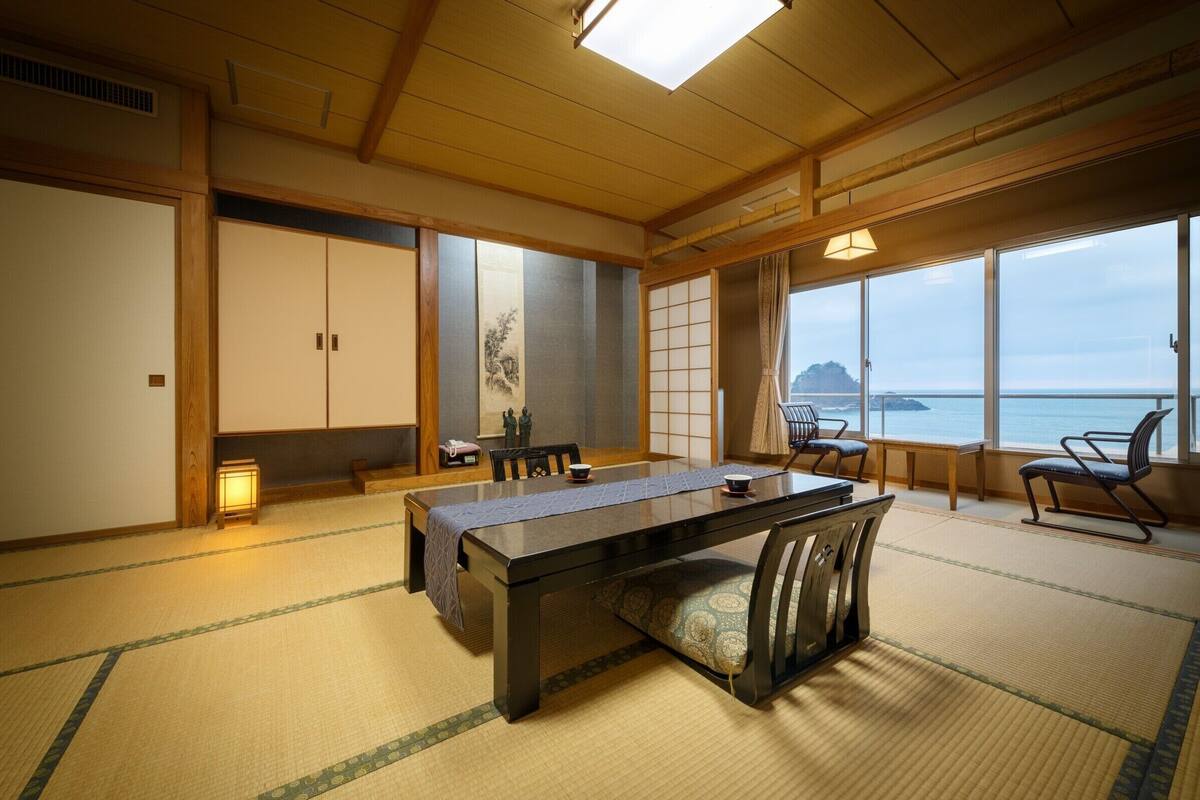 A traditional Japanese room with tatami flooring, a low table, and sliding doors.