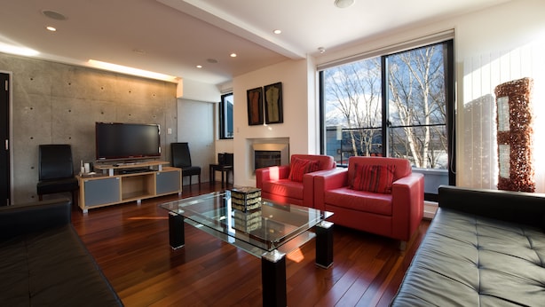 A modern living room with a glass coffee table, red sofa, and a flat-screen TV. - Udelka A (Kutchan)