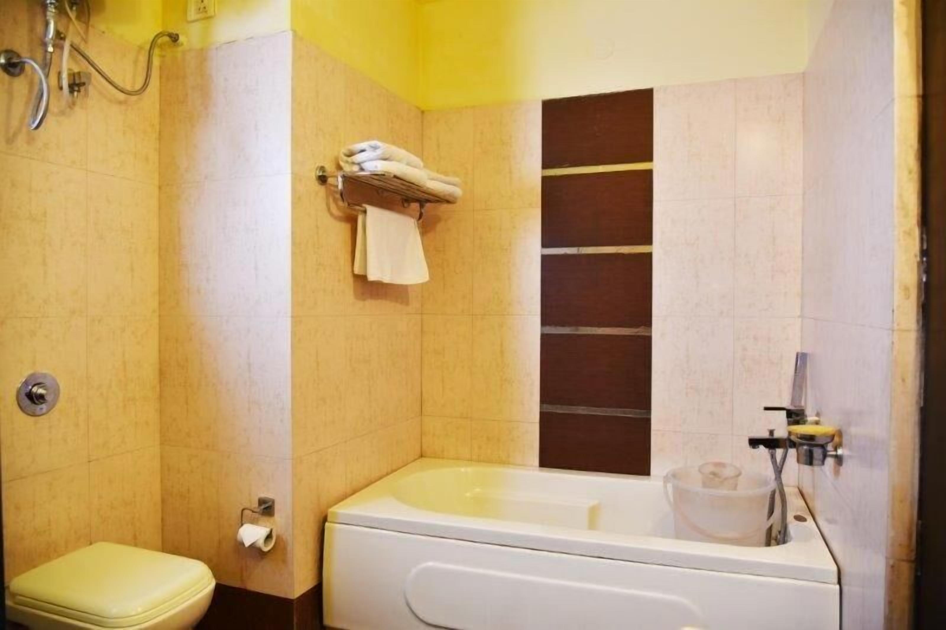 Une salle de bain avec une baignoire, des toilettes et un porte-serviettes.