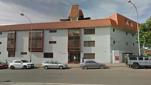 Un edificio con tetto in tegole rosse, ampie finestre e facciata piatta.