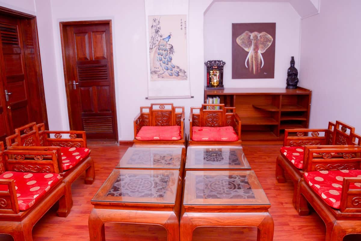 A traditional room with wooden furniture, including sofas and tables, and artwork on the walls.
