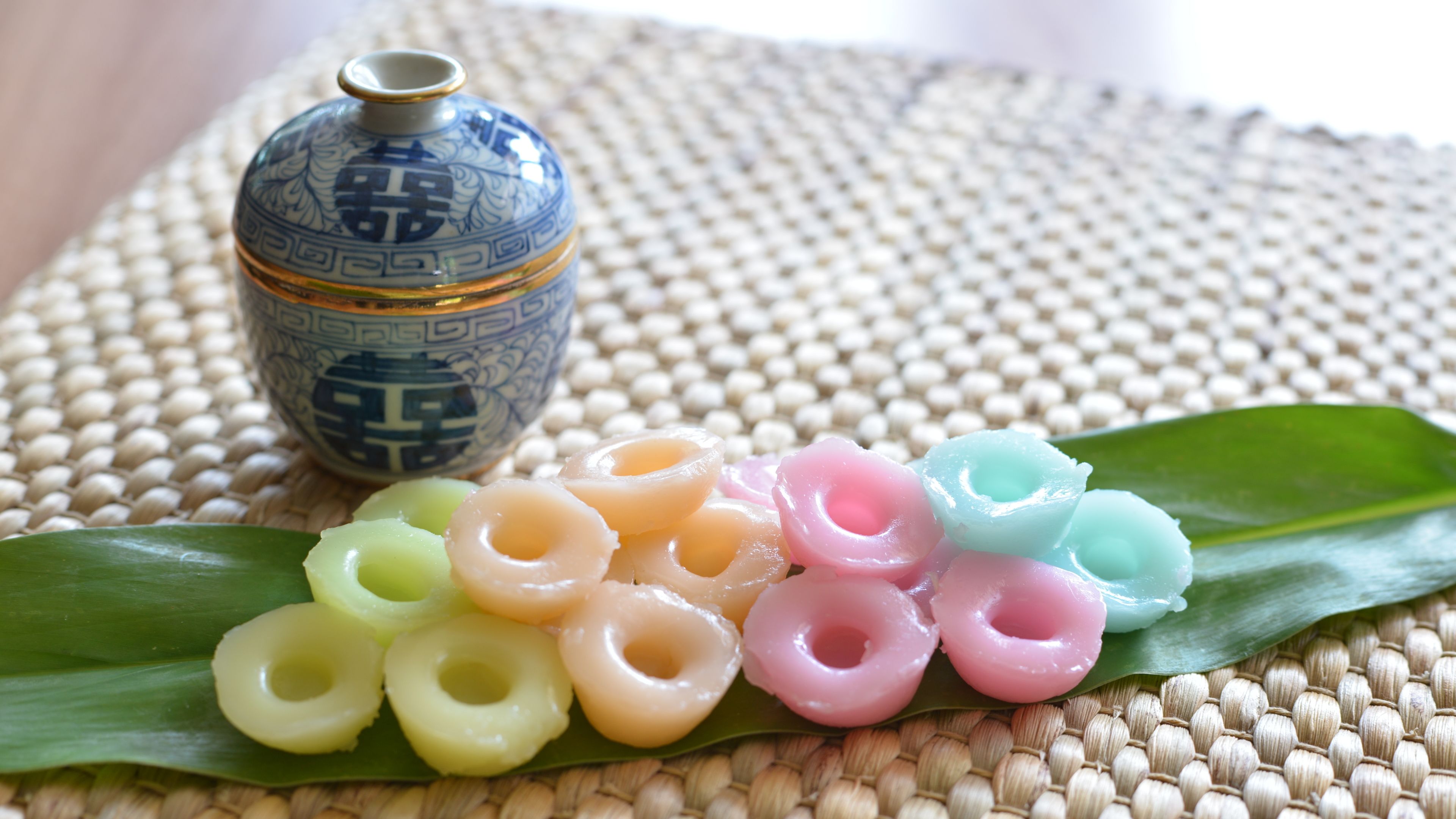 A decorative ceramic vase with intricate patterns, placed on a woven mat.
