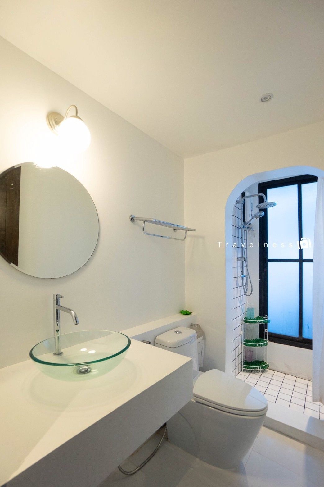 A modern bathroom with a glass sink, white vanity, and a shower with a glass door.