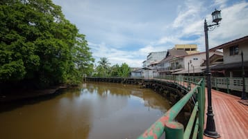 A calm river with a wooden bridge and buildings on the right.