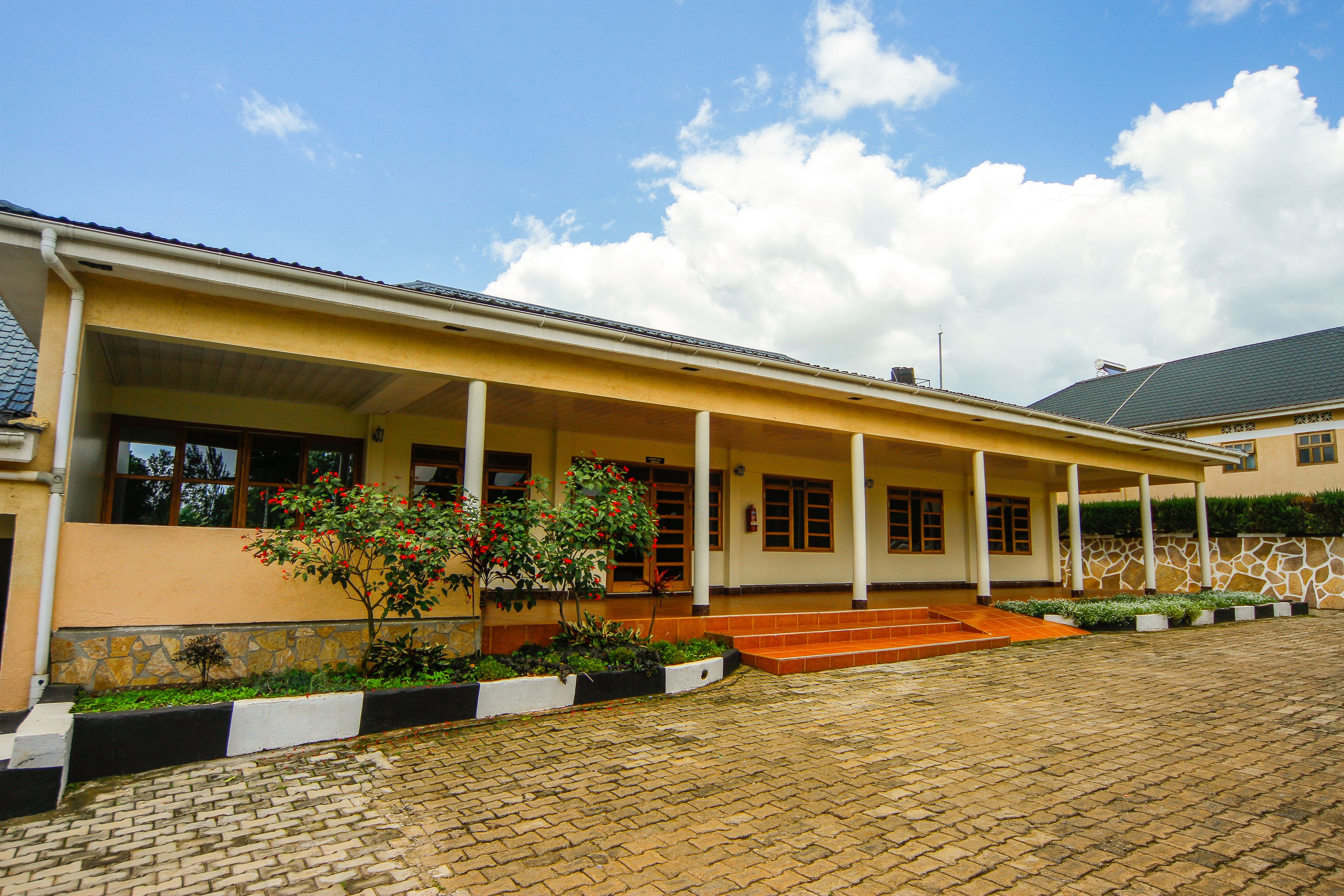 A building with a covered porch, stone steps, and a brick pathway.