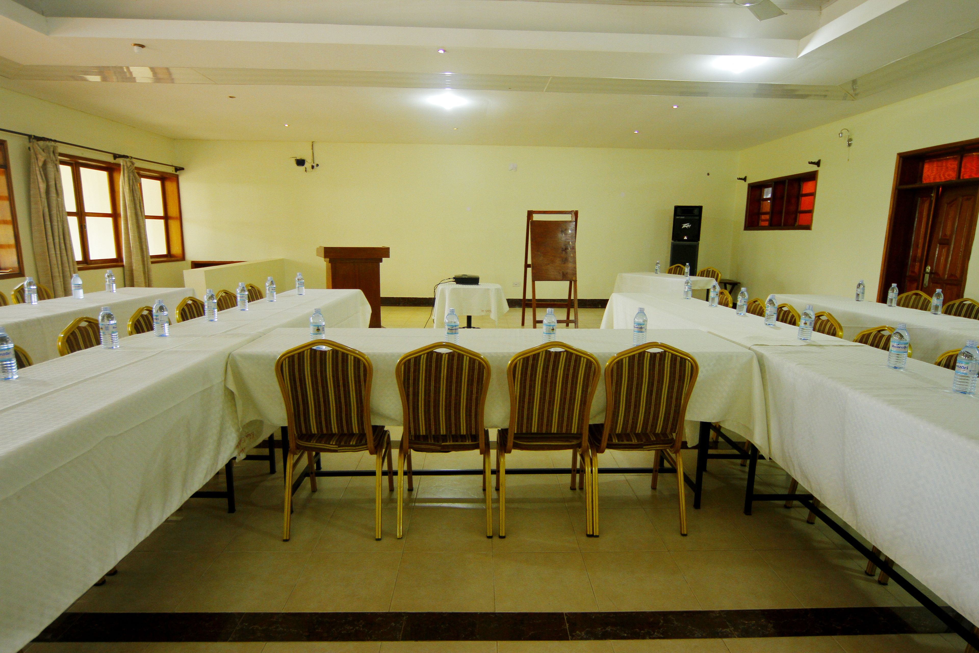 A conference room with long tables, chairs, and water bottles.