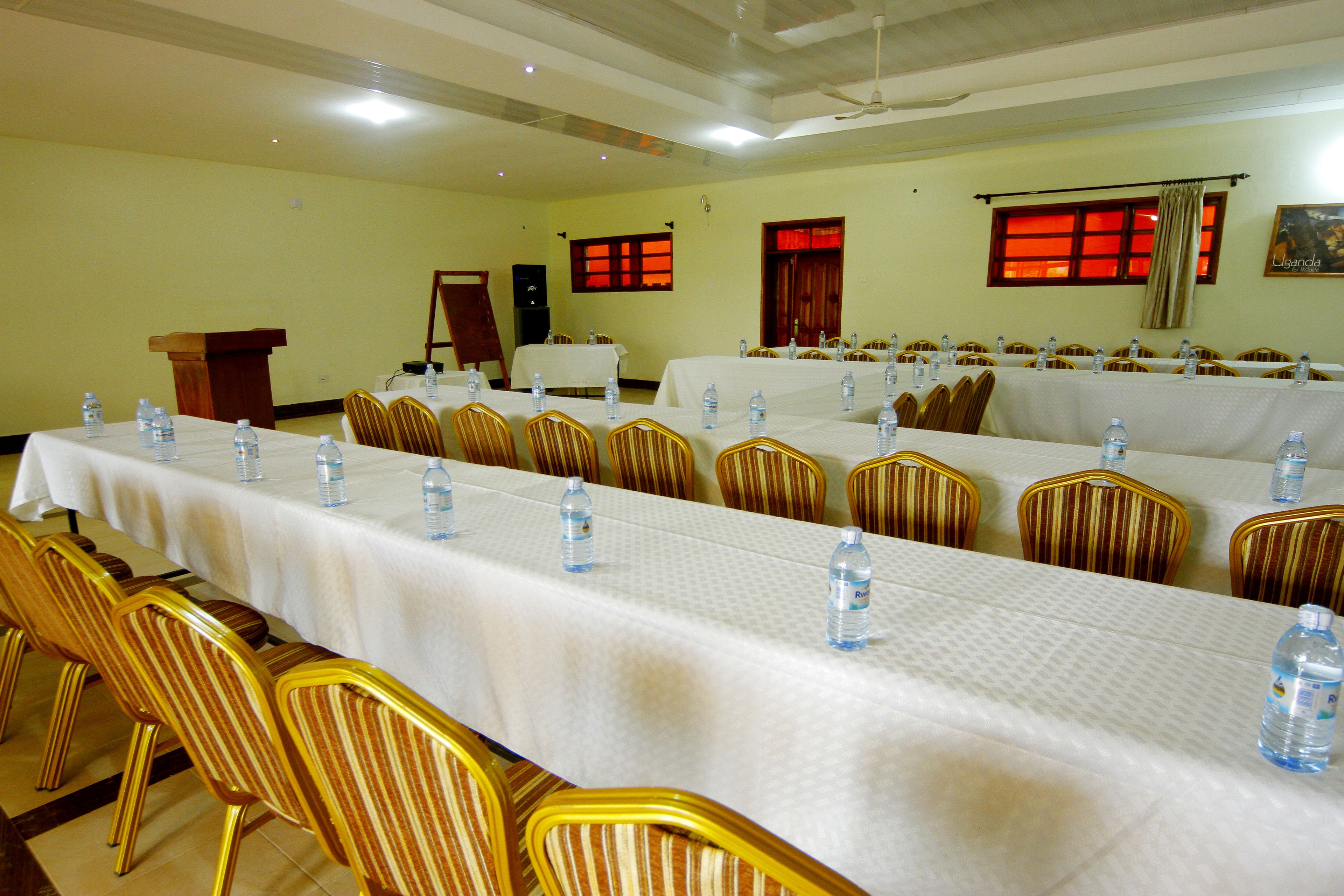 A conference room with long tables, chairs, and water bottles.
