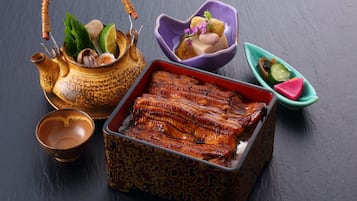 Una comida tradicional con un pescado asado, una tetera y diversos acompañamientos.