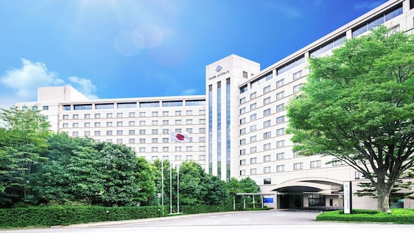 Un hotel moderno con un edificio grande, varios pisos y una bandera.