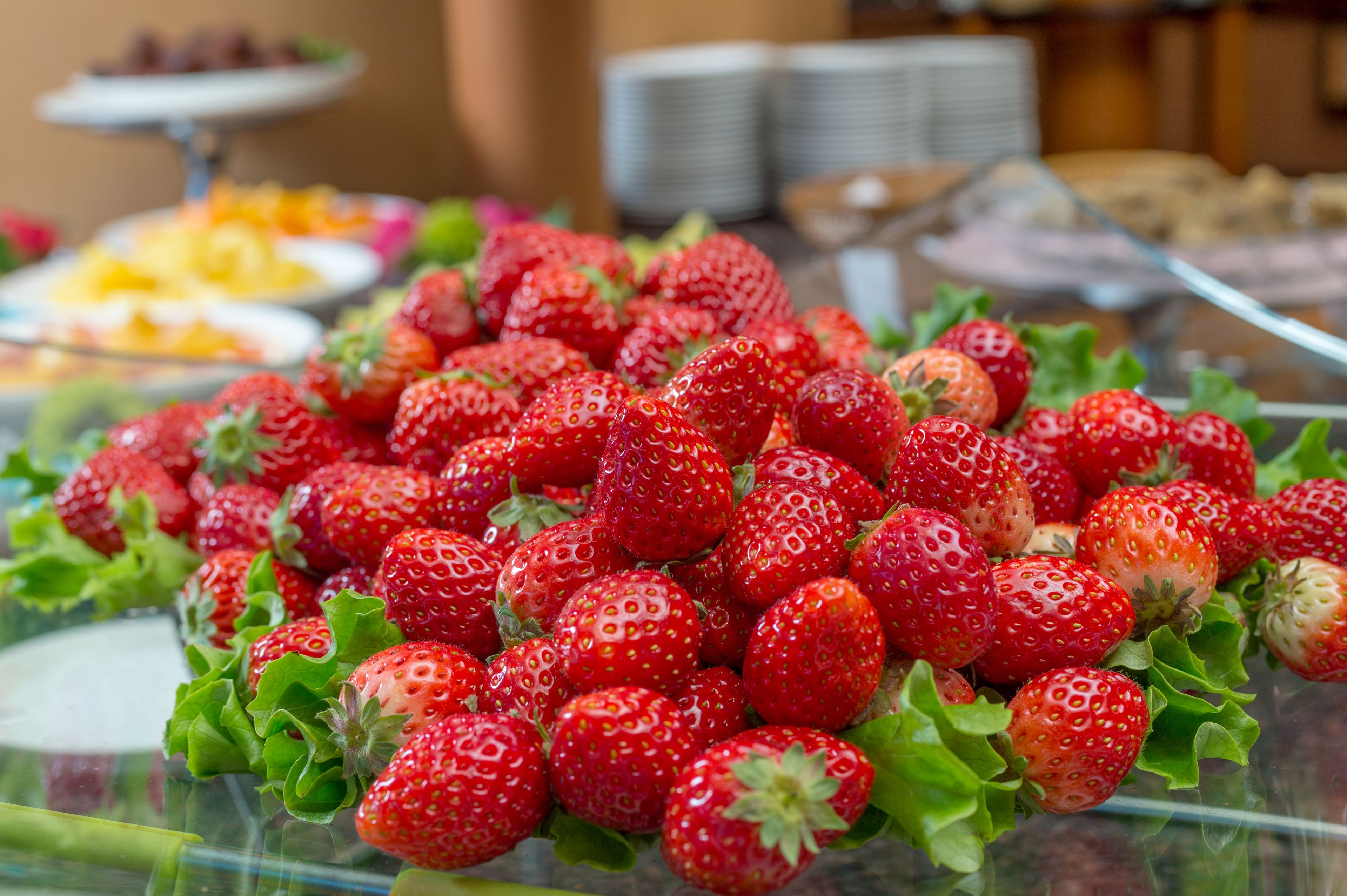 Primer plano de fresas frescas sobre una superficie de vidrio.