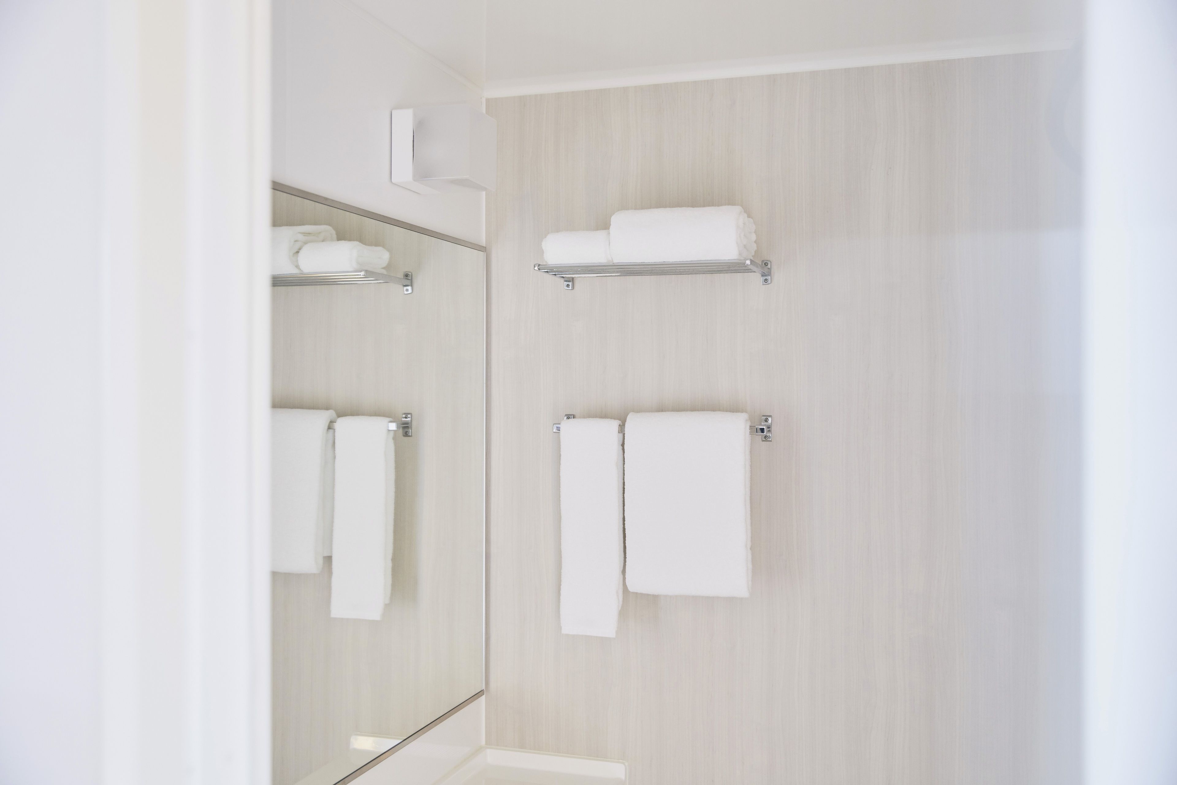 Un baño moderno con tocador de madera, espejo y perchero.