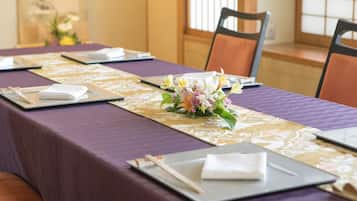Un salón de conferencias con una larga mesa dispuesta para una reunión.
