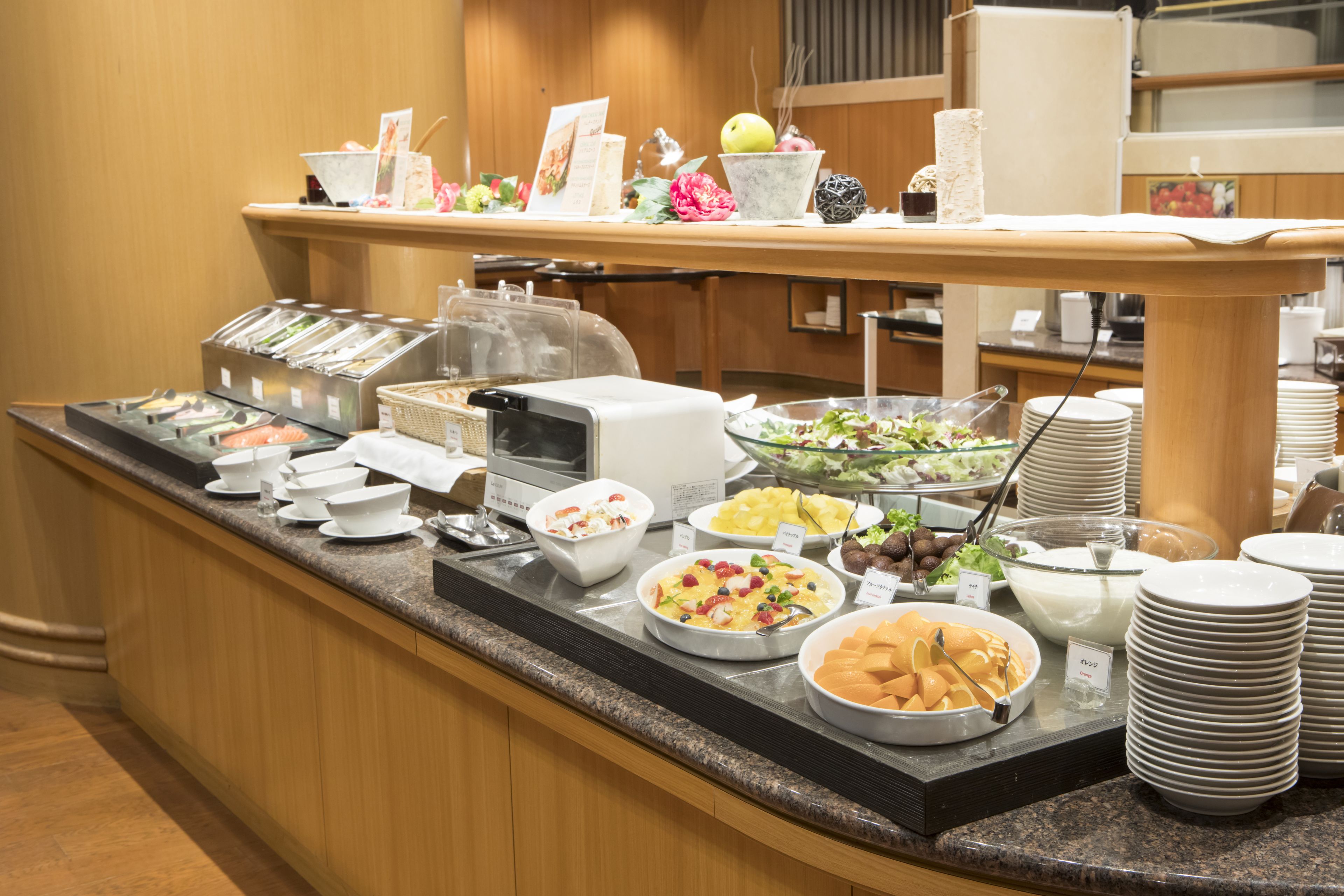 A buffet setup with various food items and serving utensils.