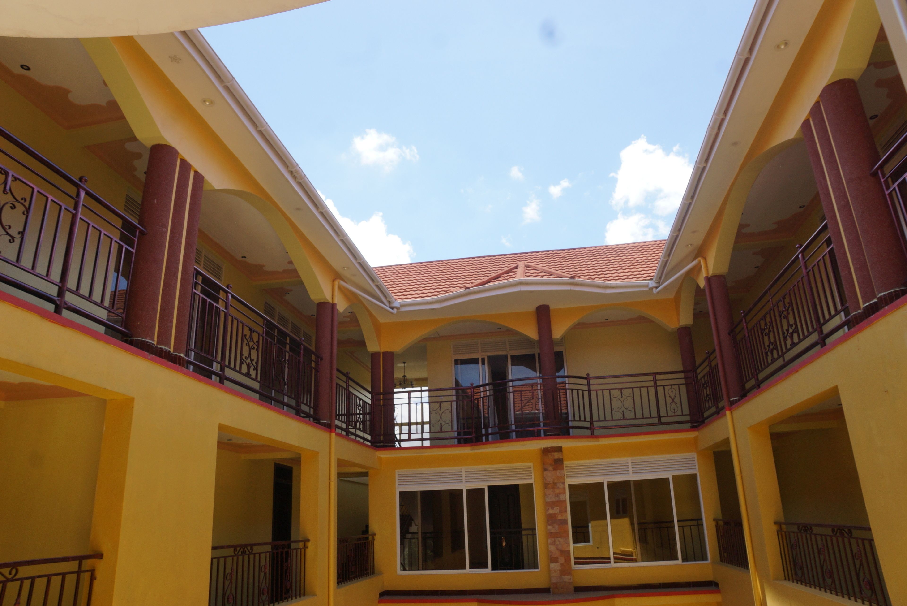 A multi-level atrium with balconies, large windows, and a tiled roof.