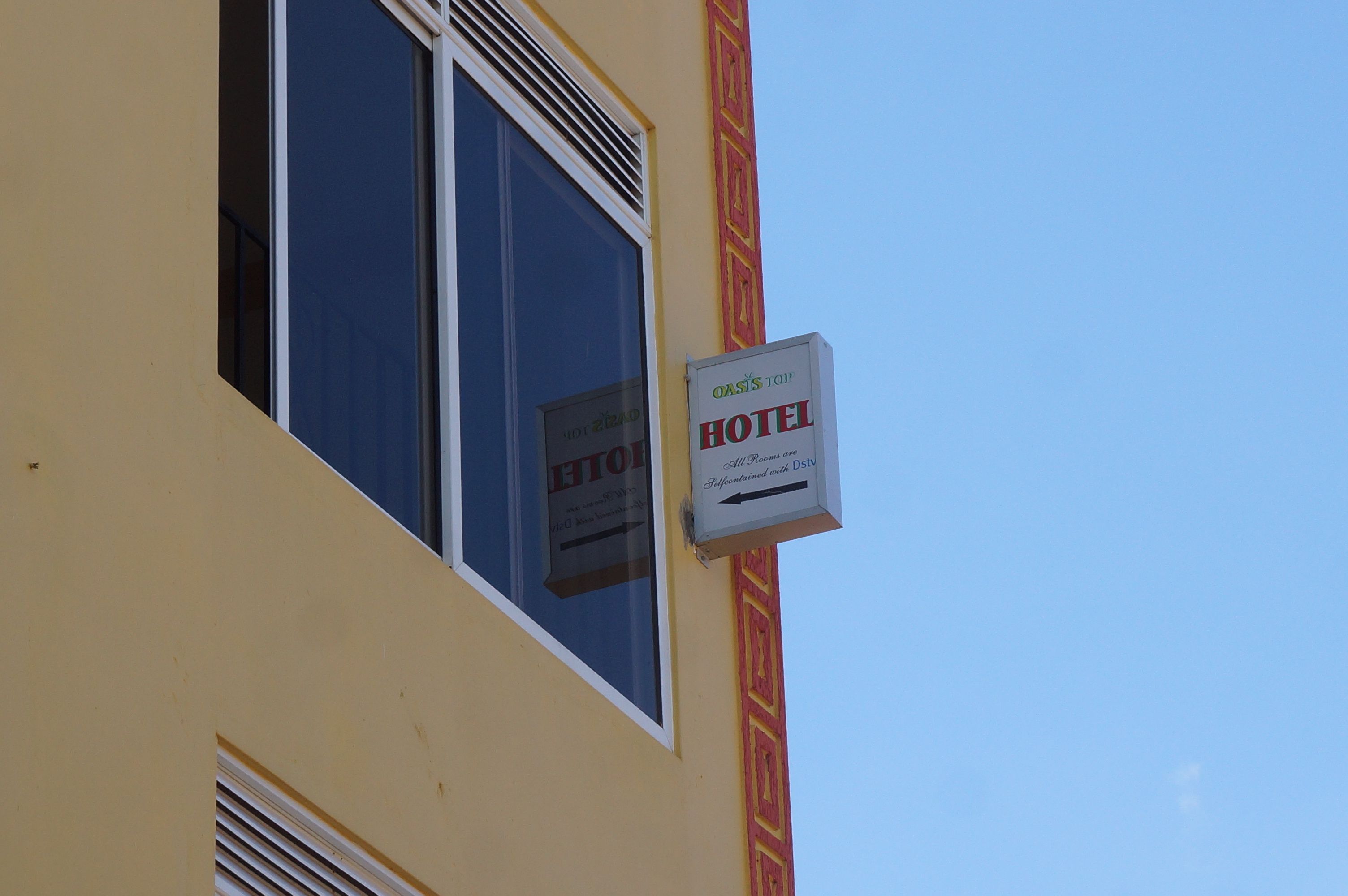 A hotel sign with a window and a decorative wall pattern.