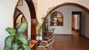 Comedor con una mesa larga, sillas, puertas de madera arqueadas y una ventana con vistas.