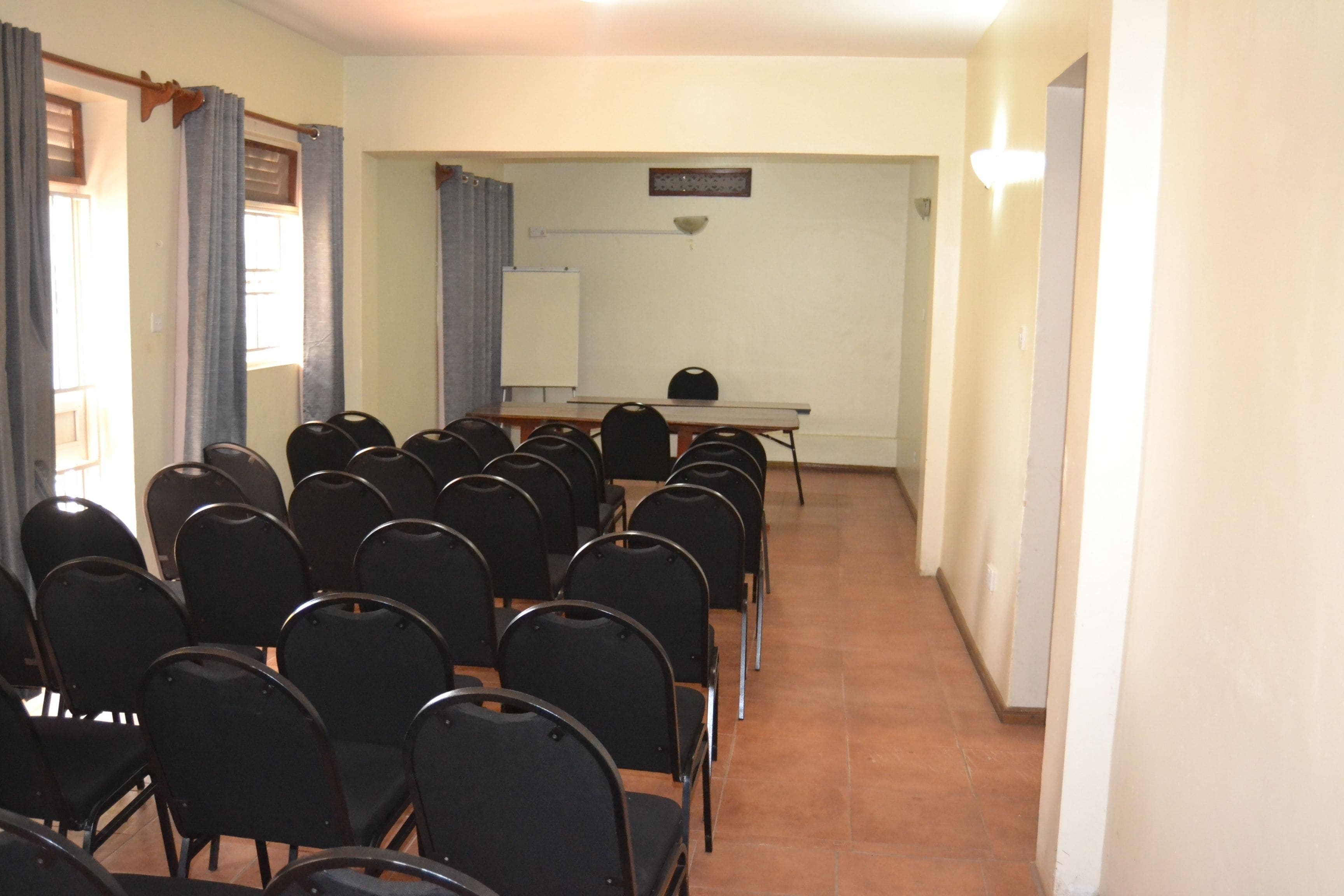 A conference room with rows of chairs, a table, and a projector screen.