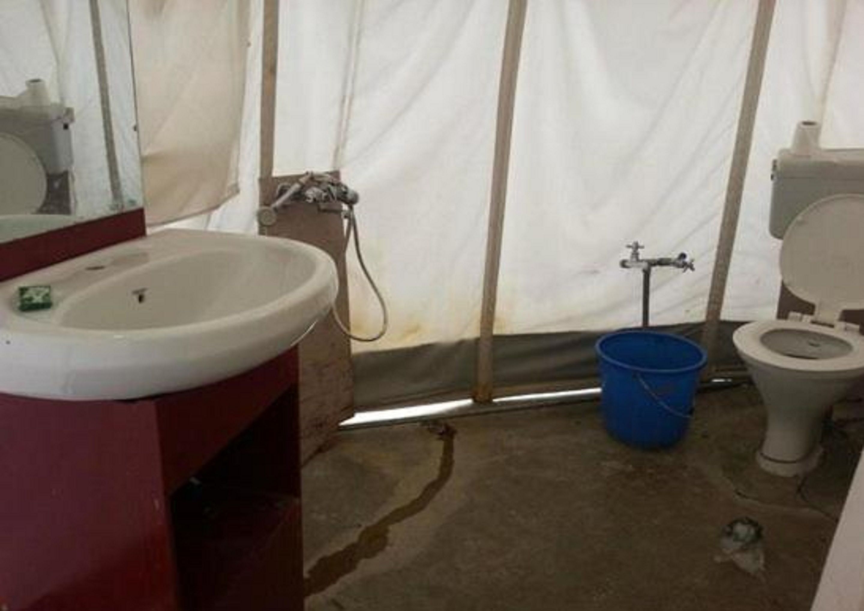 A basic bathroom with a sink, toilet, and shower area.