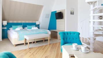 Ein modernes Hotelzimmer mit einem Bett, einem Sessel, einem Tisch mit Tassen und einer Wendeltreppe.