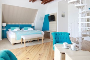 Una habitación de hotel moderna con una cama, una silla, una mesa con tazas y una escalera de caracol.