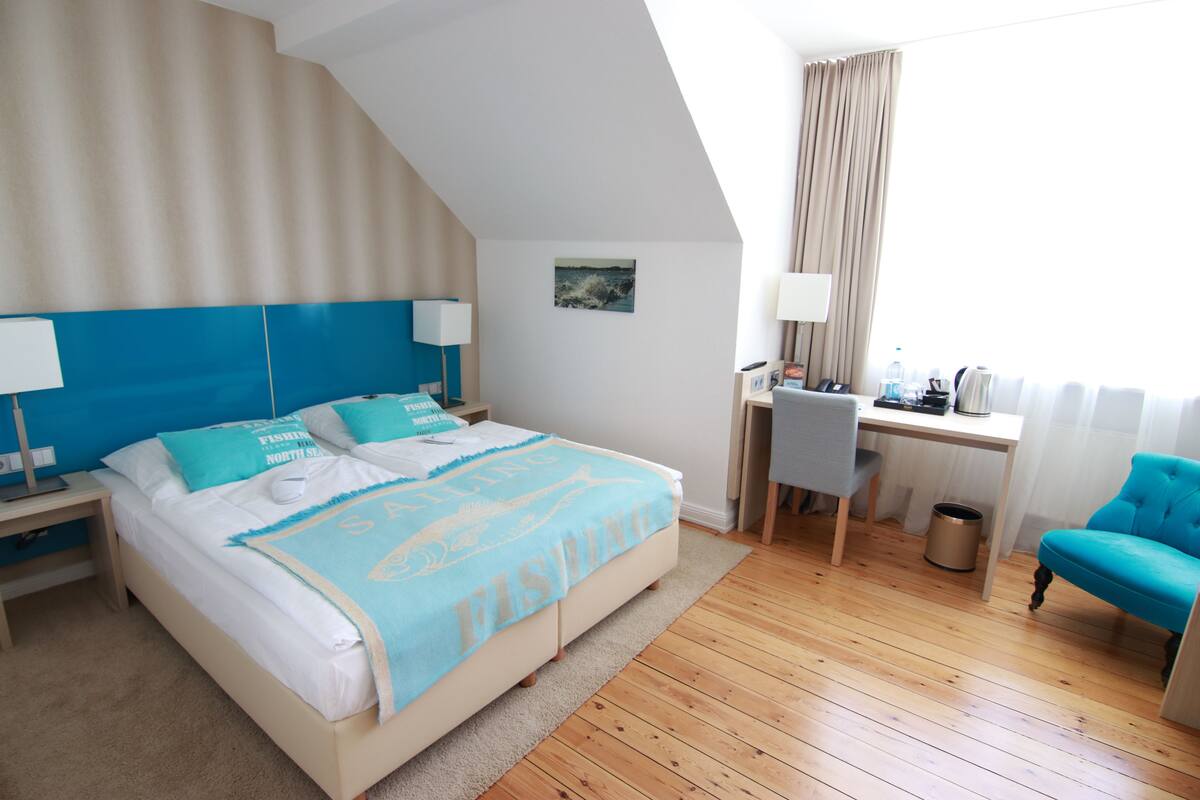 Een hotelkamer met een bed, bureau en stoel.