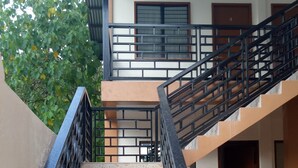 Uma escadaria com design em mosaico que leva a uma varanda no segundo andar.
