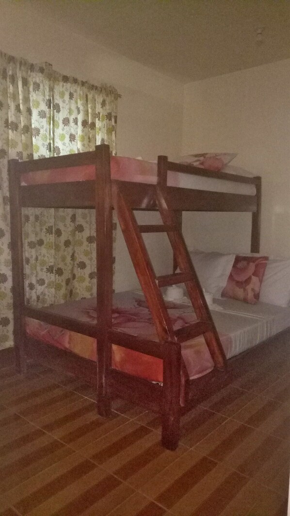 A bunk bed with a wooden frame and a ladder, a mattress, and a pillow. - JV Haven Pension (El Nido)