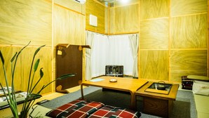 Una habitación compacta con paneles de madera, una pequeña mesa con hervidor, una banca y un radiador.