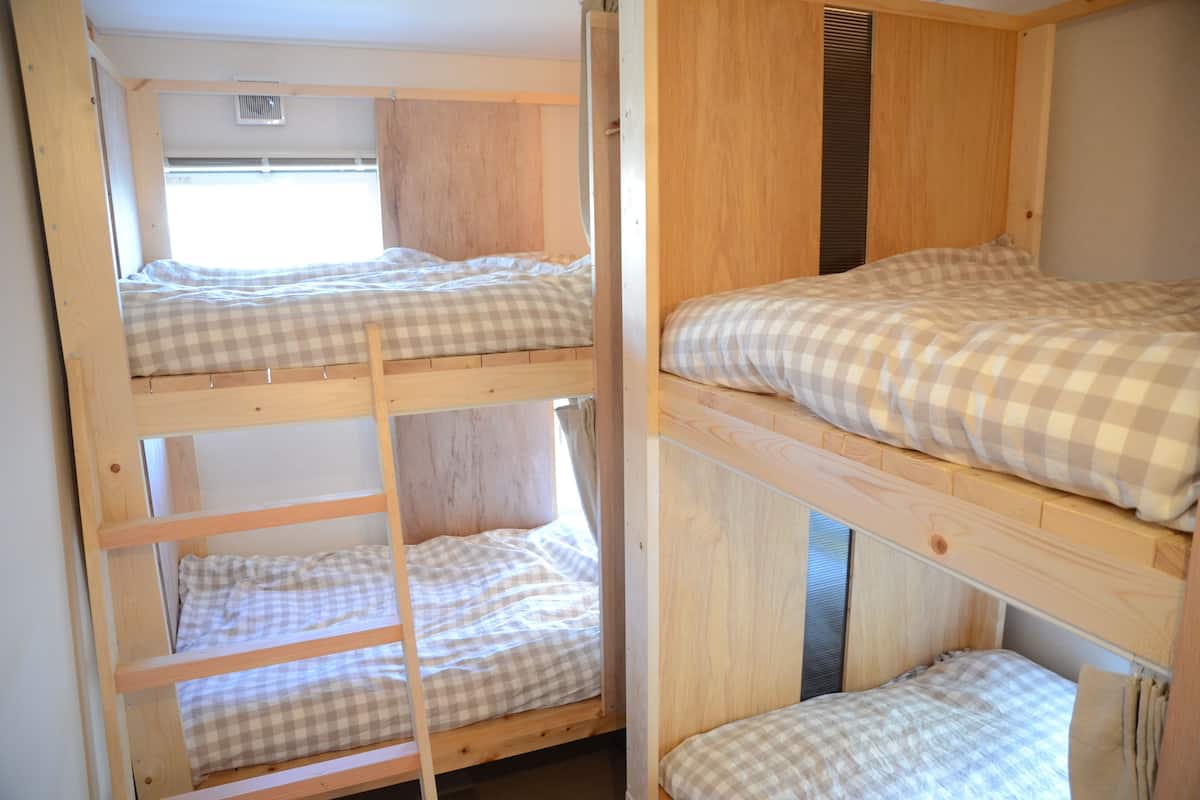 A bunk bed room with a window and a ventilation system.